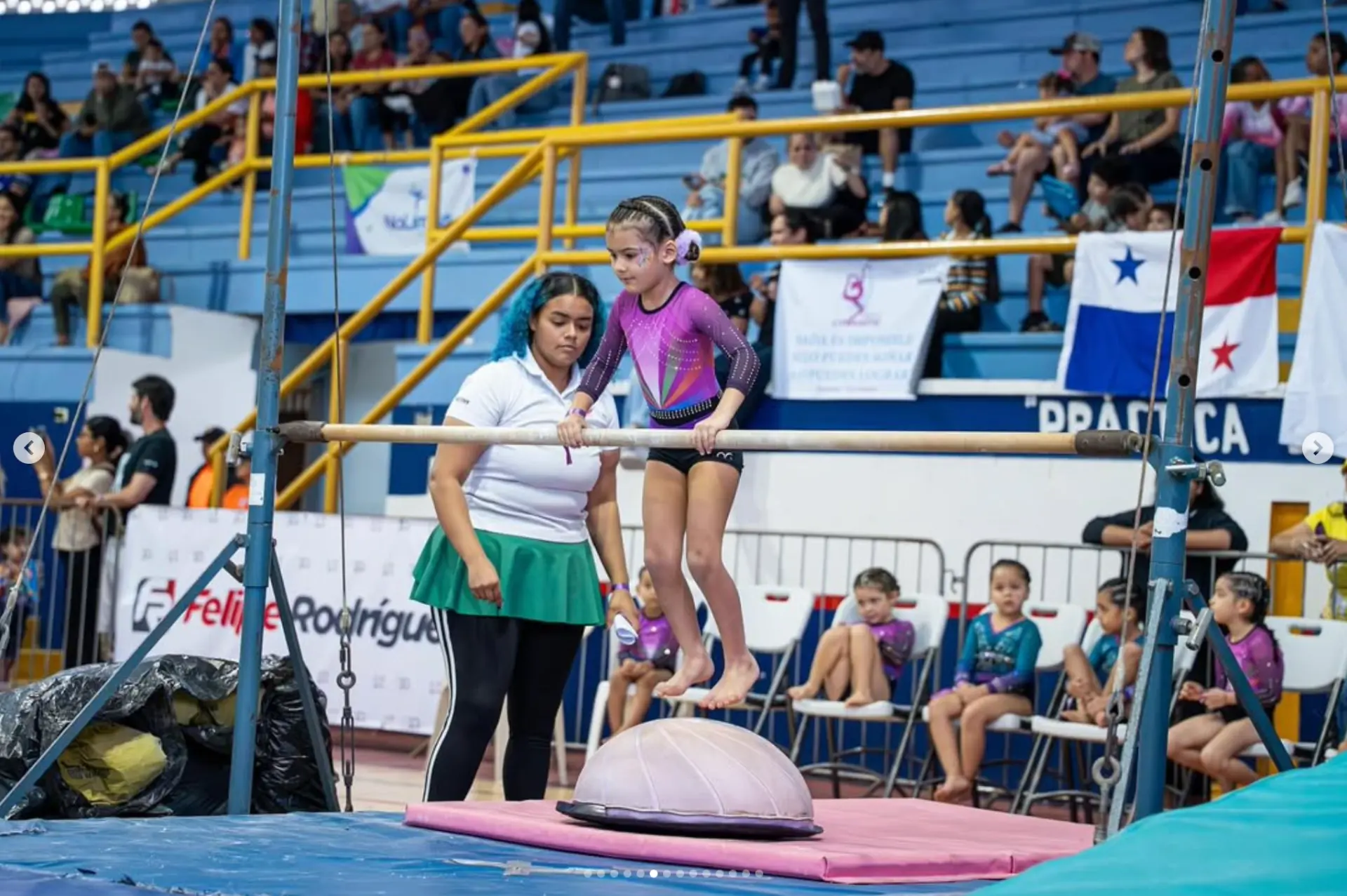 Gimnasta en barras acompañada por su entrenadora