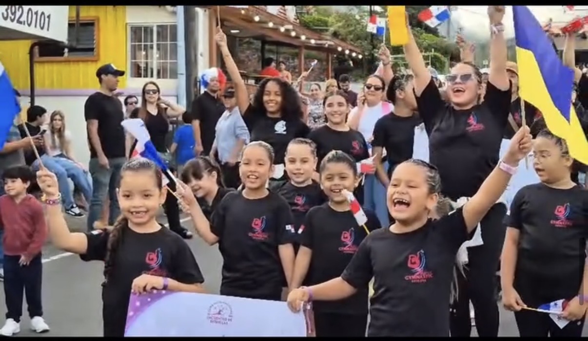 Atletas panameñas celebrando con banderas en el desfile