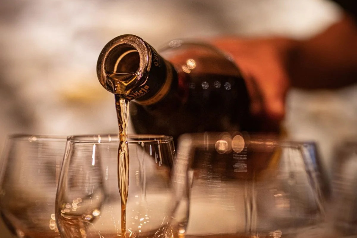 Cata de ron con copas y botellas sobre una barra de madera
